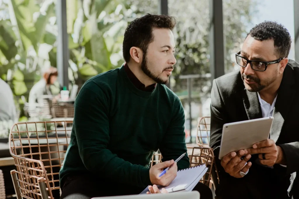 Two professionals discussing information on a tablet small business bookkeeping