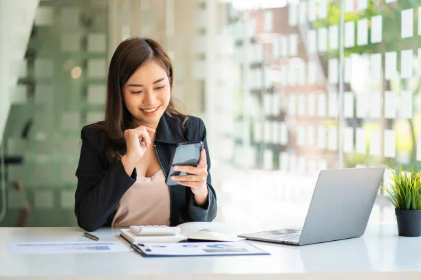 Woman using a smartphone while working at a desk